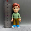 A playful cartoon PVC figurine of a boy with reddish hair wearing a green shirt and brown pants.