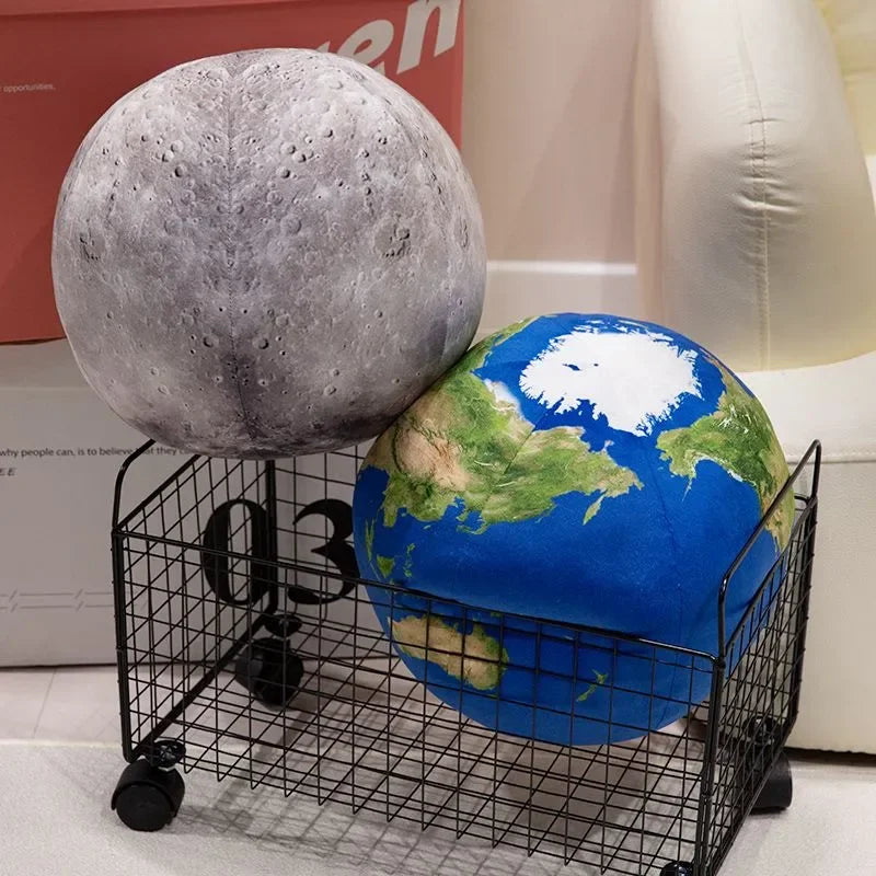 A gray spherical plush toy next to a blue Earth-like globe on a black wire rack.