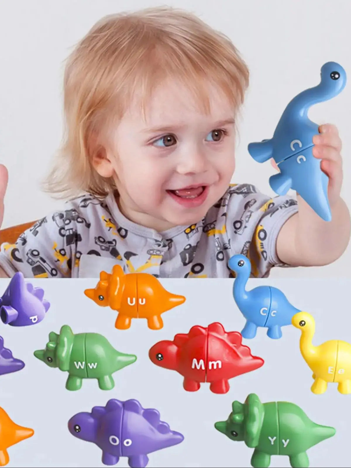 A toddler is holding a blue dinosaur toy while various colored dinosaur alphabet letters are displayed below.