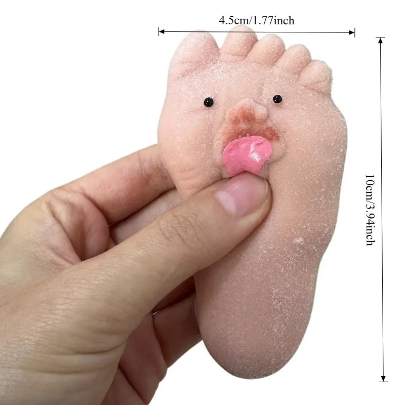 A hand holds a pink silicone foot toy with a tongue sticking out, used as a fidget item.