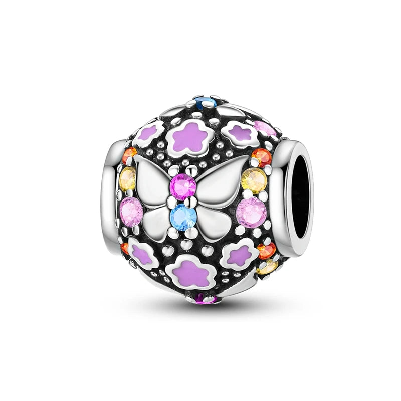 A silver heart charm bead featuring pink zircon stones and a butterfly design.