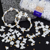 A collection of white and gold pearl beads, including various shapes like flowers, stars, and hearts, displayed with plastic 