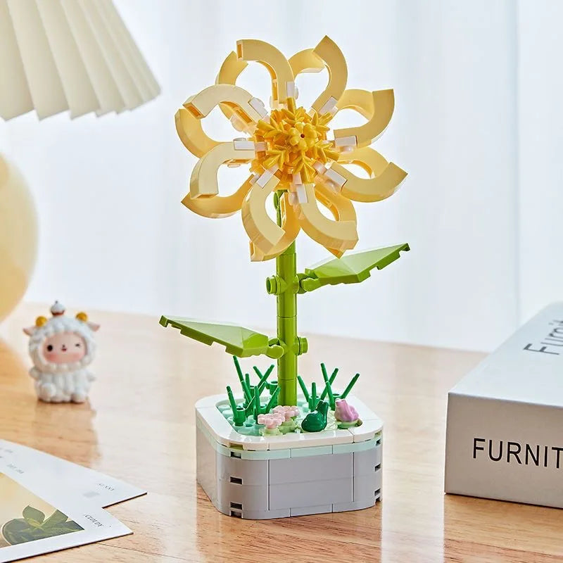 A yellow rose flower building block bouquet set with green stems and leaves displayed on a wooden table.