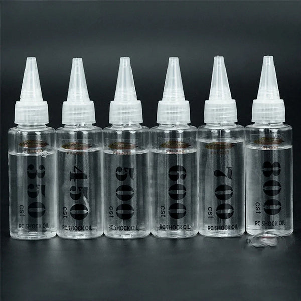 A row of clear dropper bottles containing silicone shock absorber oil for RC cars labeled with various viscosities.