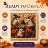A framed piece of Halloween art featuring white ghost figures and pumpkins made with pearl accents