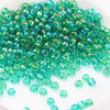 A pile of small, vibrant green glass rice beads for DIY jewelry and crafting.