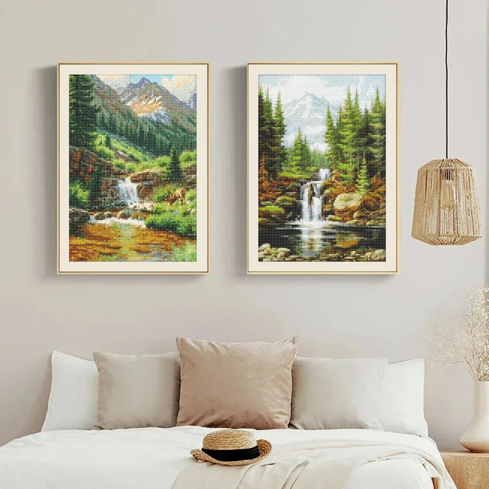 Two framed diamond paintings depicting lush green forests and waterfalls on a neutral wall.