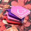 A stack of pink and purple diamond painting storage trays and organizer boxes on a sparkly background.