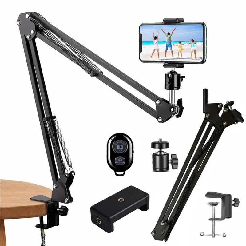 A black flexible gooseneck arm tripod with a smartphone mount and various accessories shown on a wooden surface.