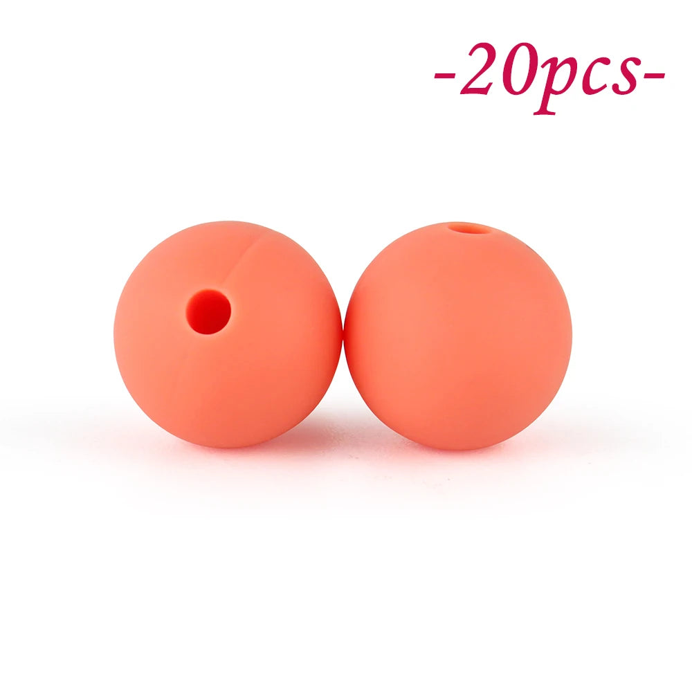 Two round, soft orange silicone beads are shown against a white background.
