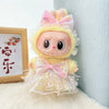 A yellow doll outfit featuring a pink bow and tulle skirt with sparkly accents.