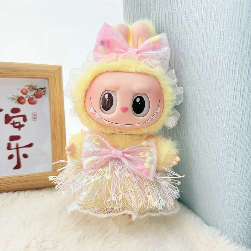 A yellow doll outfit featuring a pink bow and tulle skirt with sparkly accents.