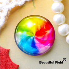Rainbow glass cabochons in a vibrant spectrum are displayed next to white pearls on a light background.