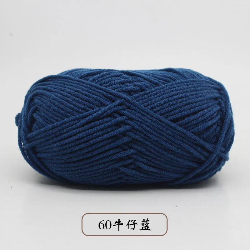 A ball of dark blue pre-dyed milk cotton yarn used for knitting and crochet.
