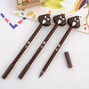 A set of three brown novelty cartoon poop gel pens with cute faces resting on a white surface.
