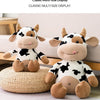 A classic multi-size display featuring two plush cow stuffed animals in black and white against a light background.