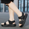 A close-up shot of a pair of black boys' non-slip summer sport sandals worn on a person's foot.