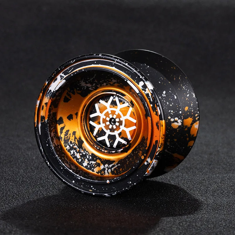 Close-up view of a black aluminum alloy yo-yo with an orange and black marbled finish.