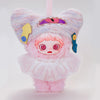A fluffy pink plush doll with purple ears and pink hair, featuring gold and blue accessories.