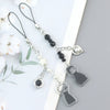 Silver and black anime-inspired keychain with removable charm featuring a character silhouette.
