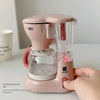 A pink electric coffee maker and water dispenser is shown on a white surface.