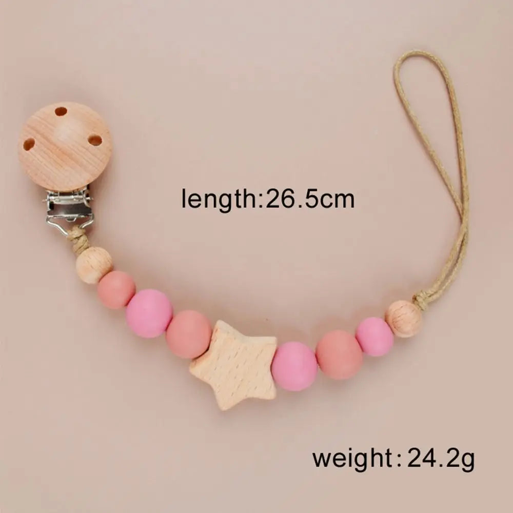 A wooden pacifier clip featuring silicone beads and a star shape on a leather cord.