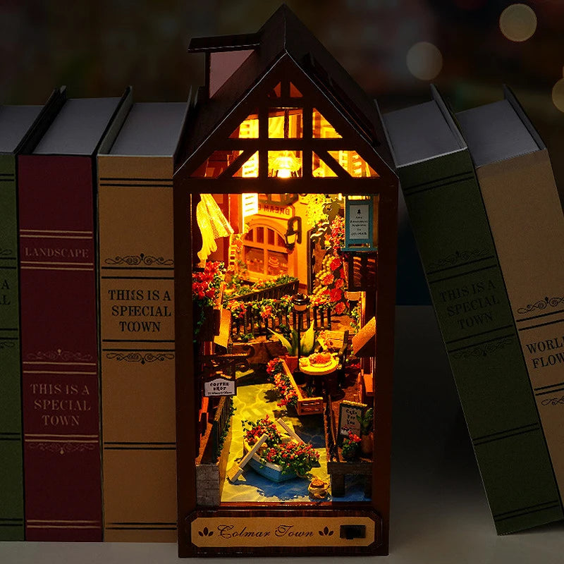 A miniature bookshelf book nook kit featuring a detailed scene with LED lights and miniature buildings.