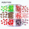 A clear plastic container filled with various festive Christmas polymer clay slices in red, green, and white.