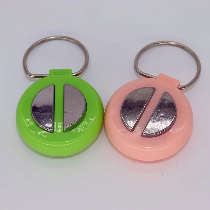 A pair of green and pink electric shock hand buzzer prank toys with metal rings.