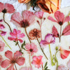 A collection of pink and orange floral PET stickers on a textured paper background.