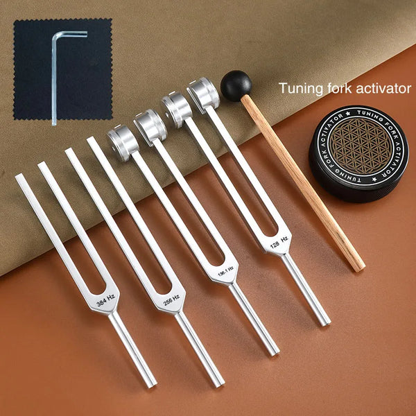 A set of tuning fork activators including various frequency forks and a wooden activator tool on a brown background.