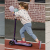 A young girl wearing minimalist barefoot sneakers is running outdoors with a balloon.