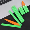 A collection of bright green and orange 3D printed butterfly knife fidget toys lying on a black surface.