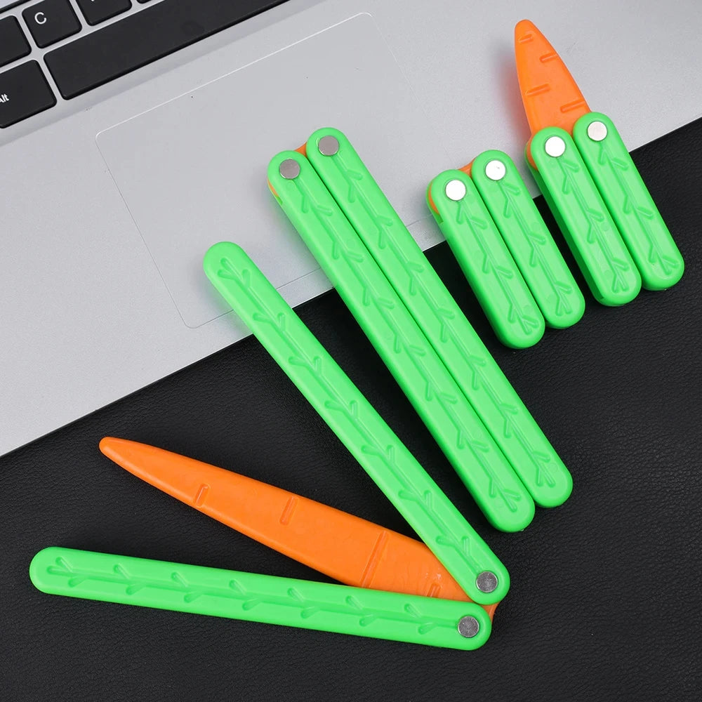 A collection of bright green and orange 3D printed butterfly knife fidget toys lying on a black surface.