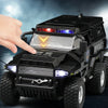 A black SWAT City Police truck diecast toy with lights and sounds being held by a hand.
