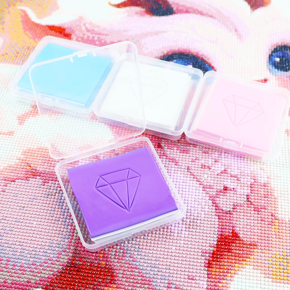 A collection of diamond painting clay in various colors, including purple, pink, and blue, displayed on a colorful background