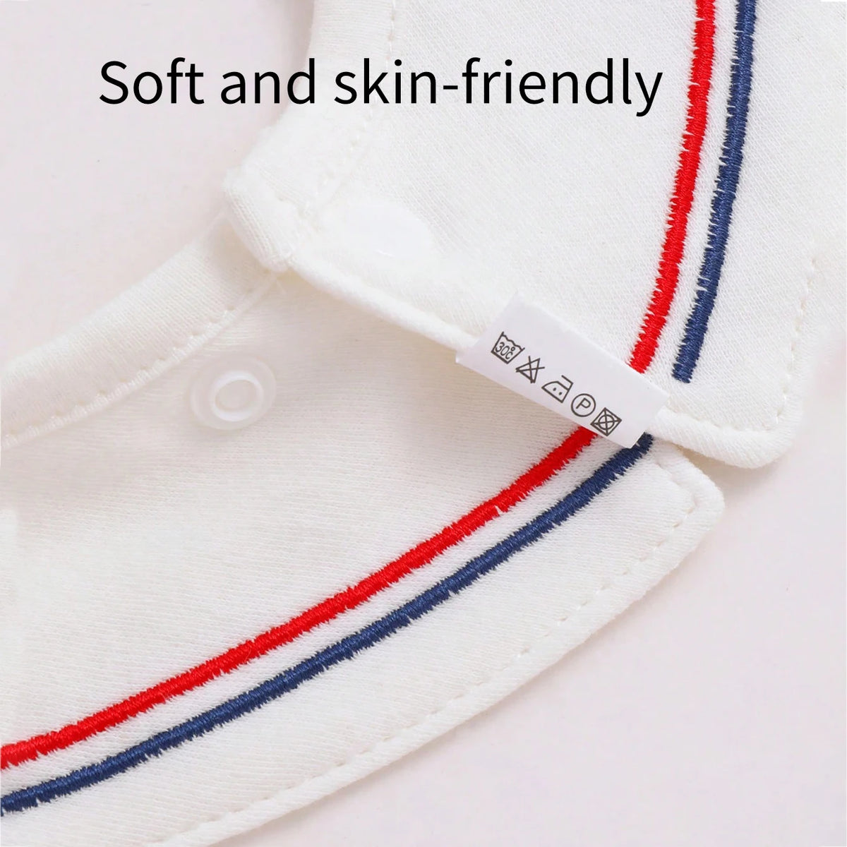 Close-up of a white baby bib with red and blue stripes, showing the soft fabric texture.