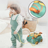 A toddler is playing with a green musical phone toy for toddlers that features lights and sounds.