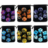 A set of polyhedral dice in various colors and sizes stored in black fabric bags.