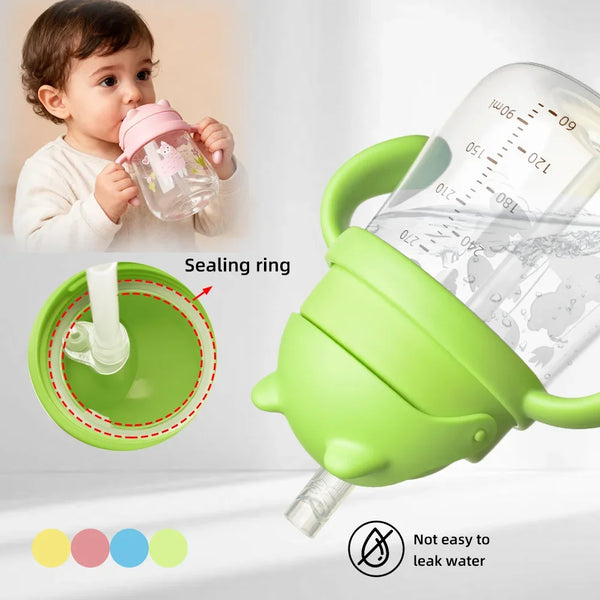 A green silicone baby straw cup with a sealing ring is shown next to a baby using it.