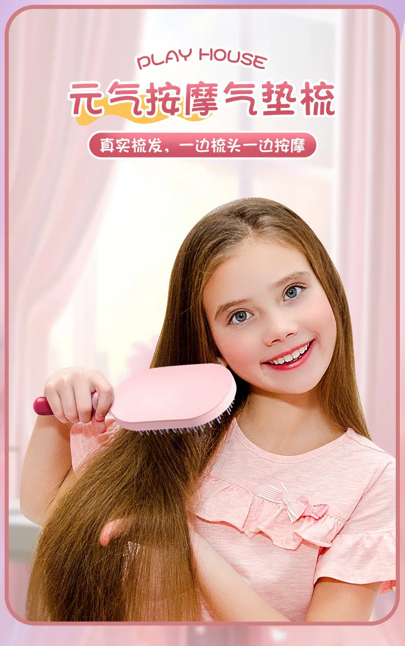 A young girl is holding a pink hair styling tool and a hairbrush, demonstrating the use of the pretend play set.