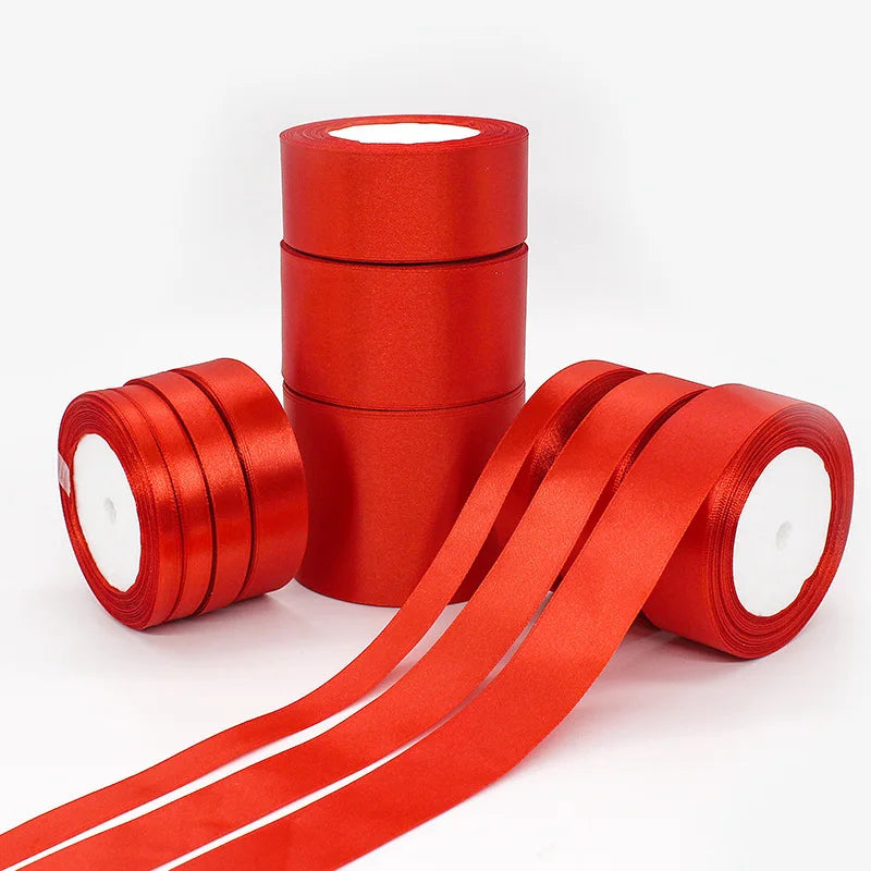 A roll of red satin ribbon for gift wrapping and crafts, shown in various forms.
