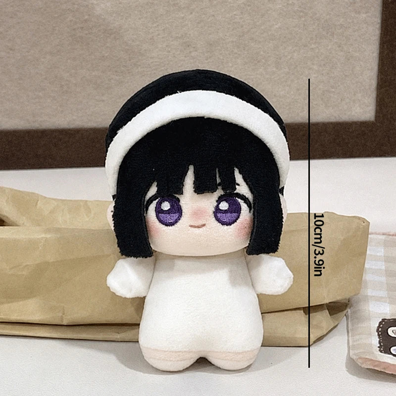 A black and white plush keychain featuring a girl with large purple eyes.