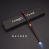 A dark wooden magic wand with a glowing tip is displayed on a black surface.