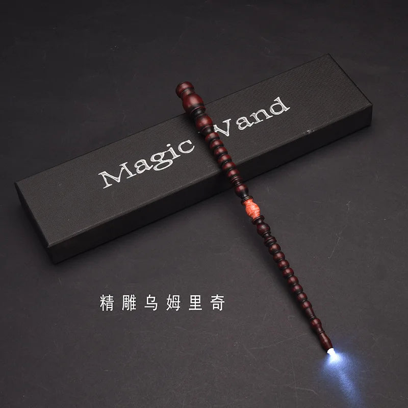 A dark wooden magic wand with a glowing tip is displayed on a black surface.