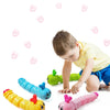 A young boy is interacting with several colorful wind-up caterpillar crawling toys.