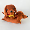 A brown dachshund plush toy with floppy ears and a yellow bone detail.
