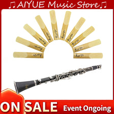 A pack of ten yellow and natural wood clarinet reeds arranged in a semi-circle with a silver instrument shown below.