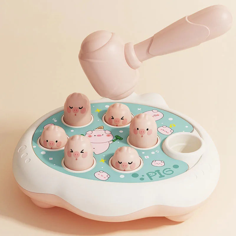 A pink Montessori animal hammer toy with a large mallet and several small pig figures on a light blue tray.
