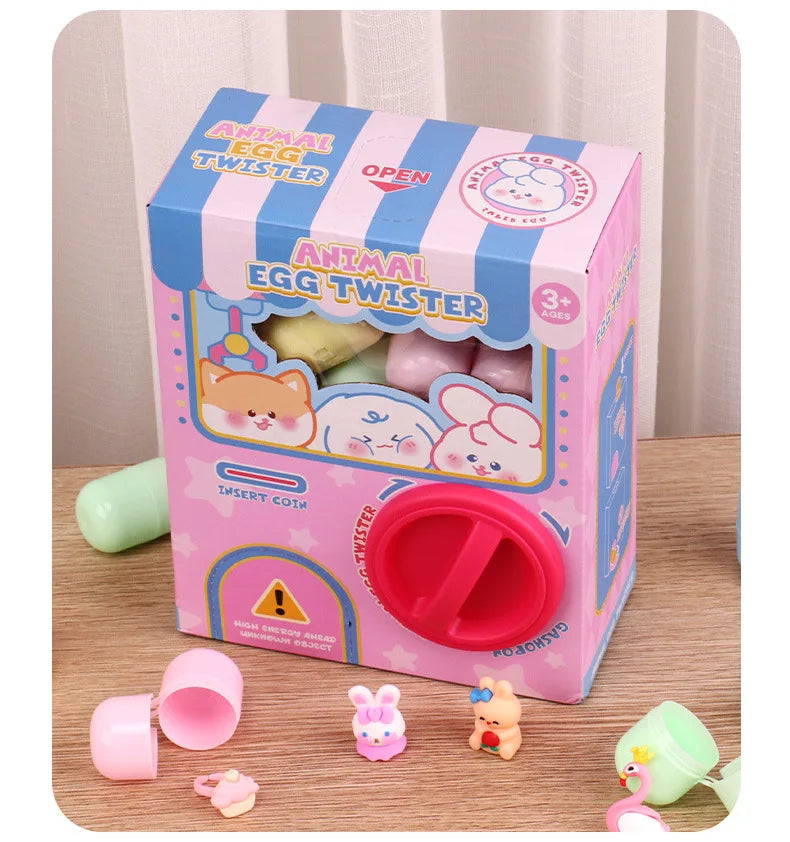 A box of Animal Egg Twister toys with pink and blue packaging and several plastic components scattered on a wooden surface.